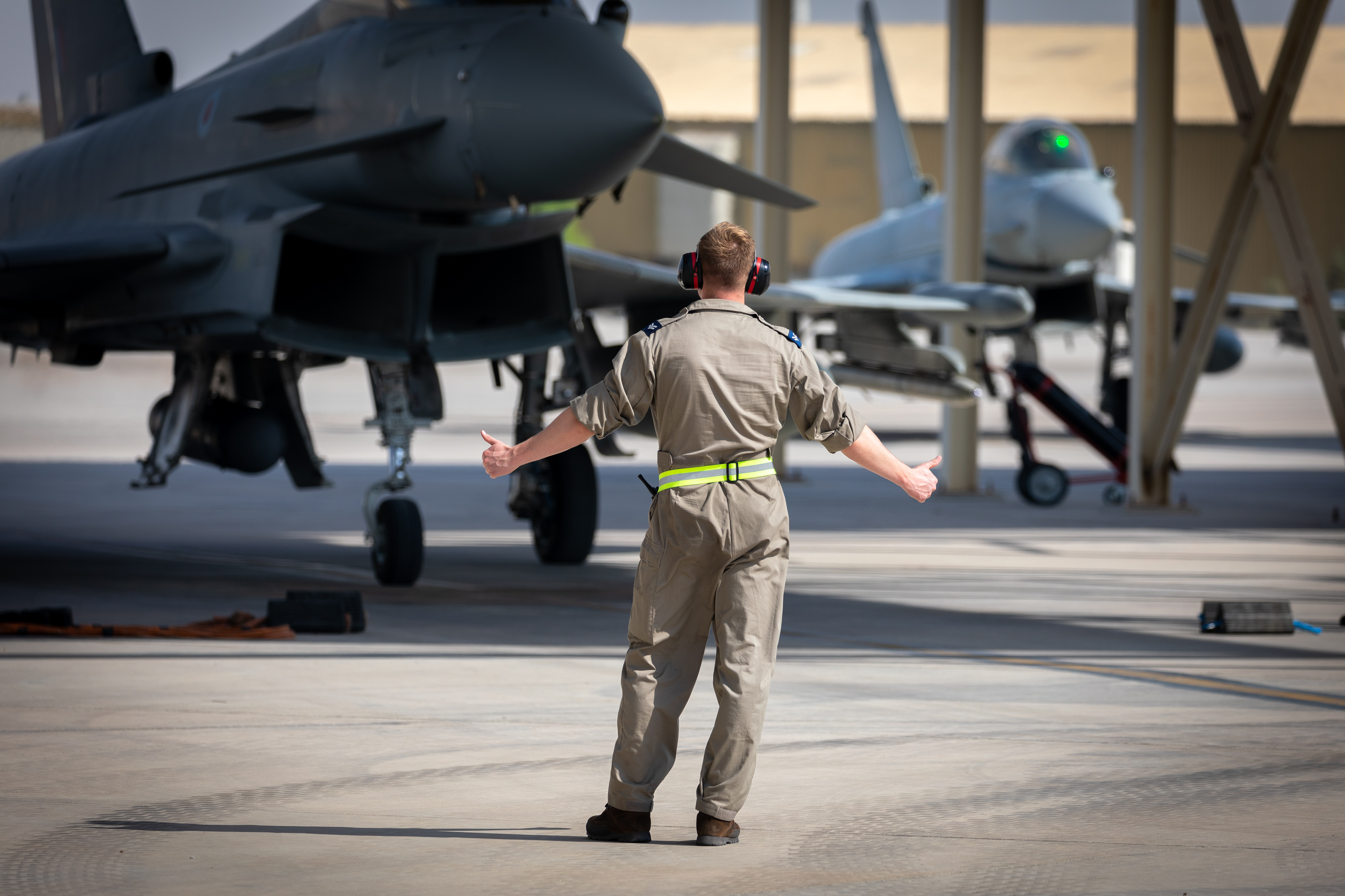 Image shows RAF aviator guiding Typhoons on the airfield